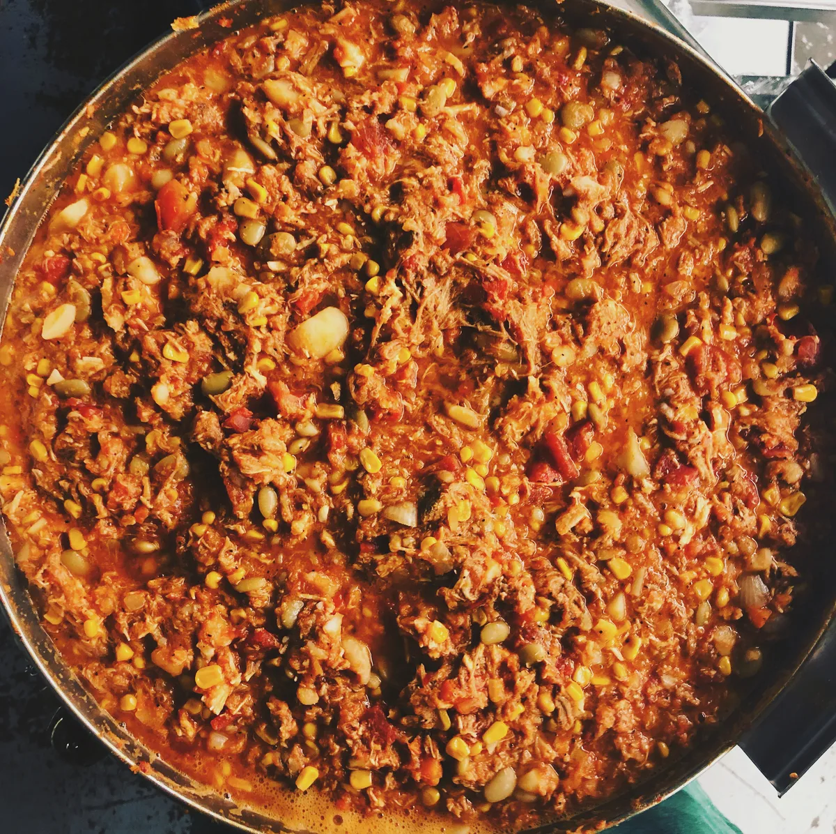Overhead closeup of BBQ King's homemade Brunswick stew, packed with corn, lima beans, and pulled pork