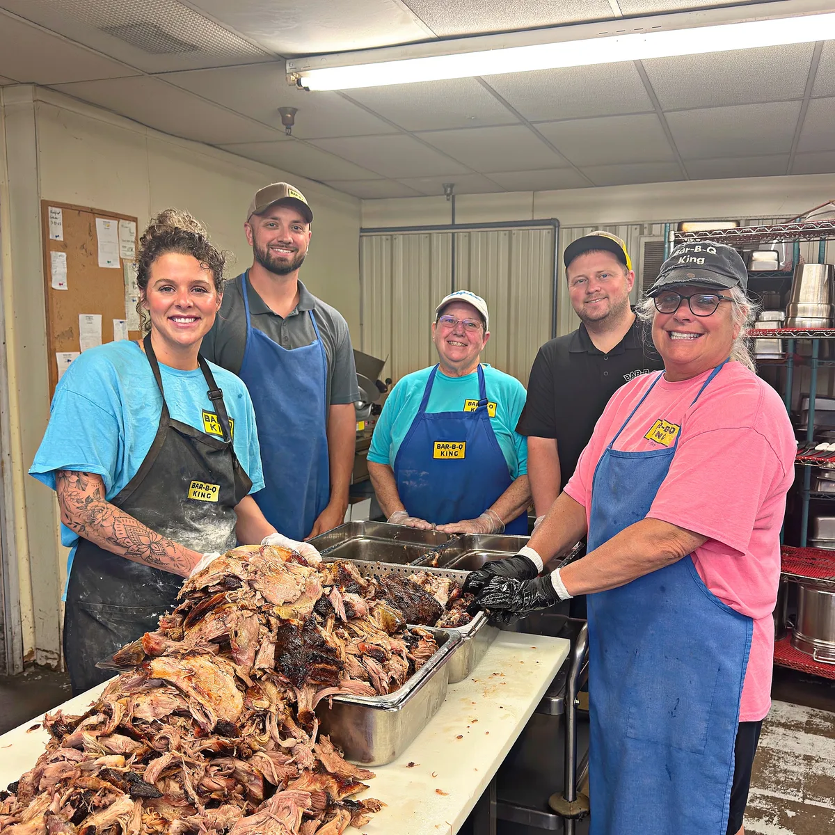 Staff team portrait around the chopping table in the smokehouse